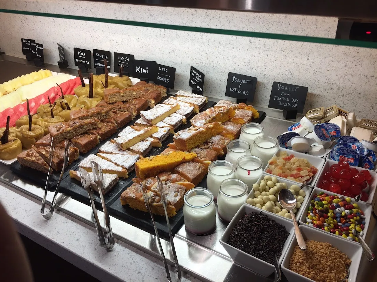 A dessert display case with an assortment of pastries and cakes