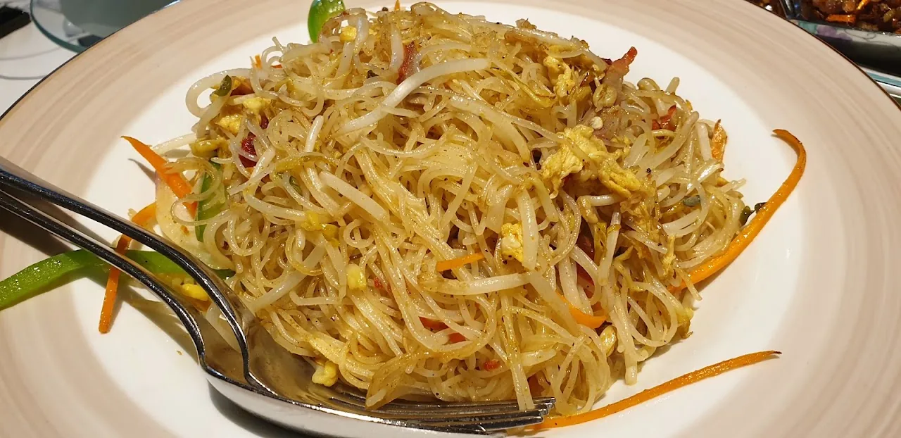 A plate of stir-fried noodles with bean sprouts and vegetables