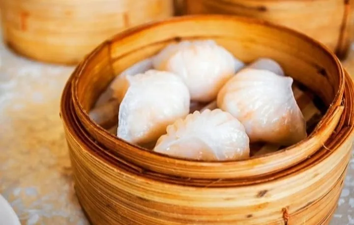 A bamboo steamer of translucent shrimp dumplings (har gow)
