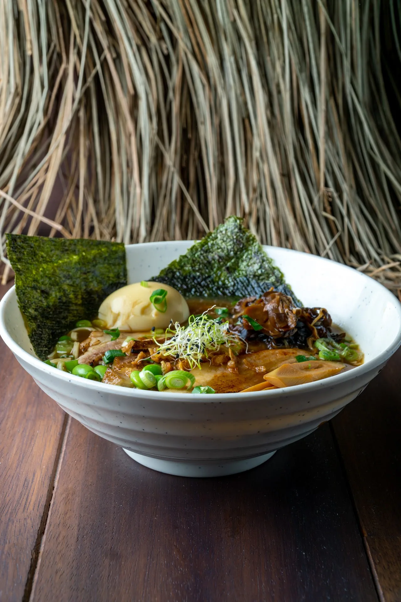 A bowl of ramen with broth, greens, and toppings