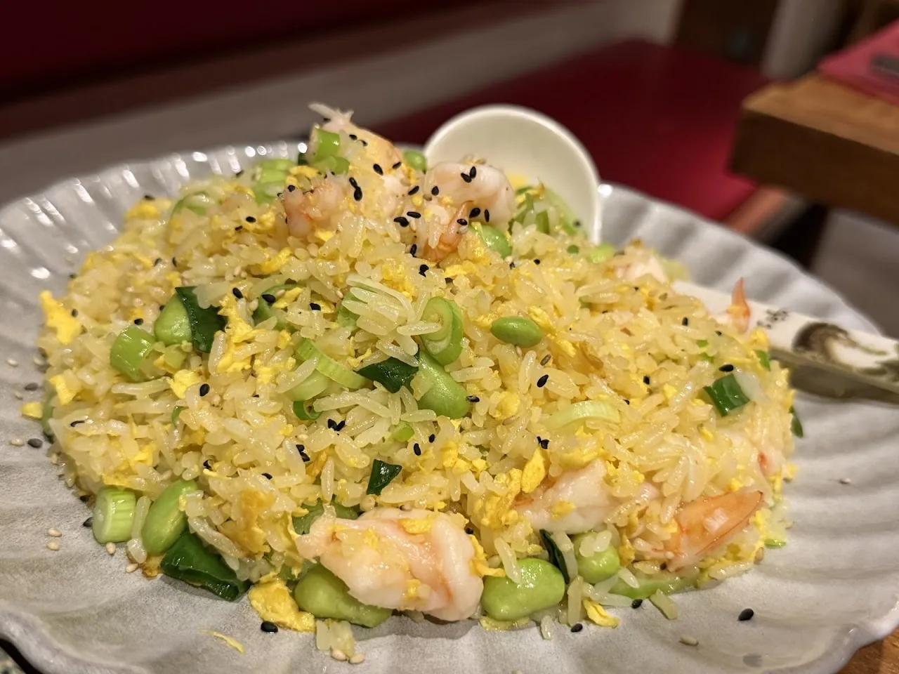 A plate of fried rice with shrimp and vegetables