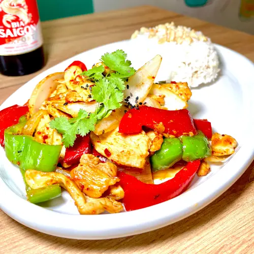 Stir-fried chicken with bell peppers and onion, garnished with cilantro and sesame seeds, served with a side of white rice, Tutu Vietnamese Cuisine