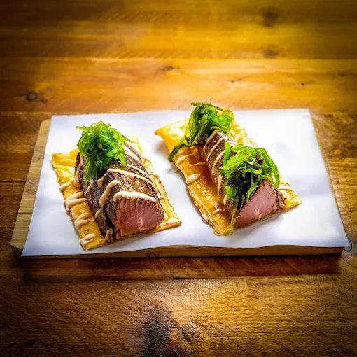 Sliced duck breast with greens on toasted bread