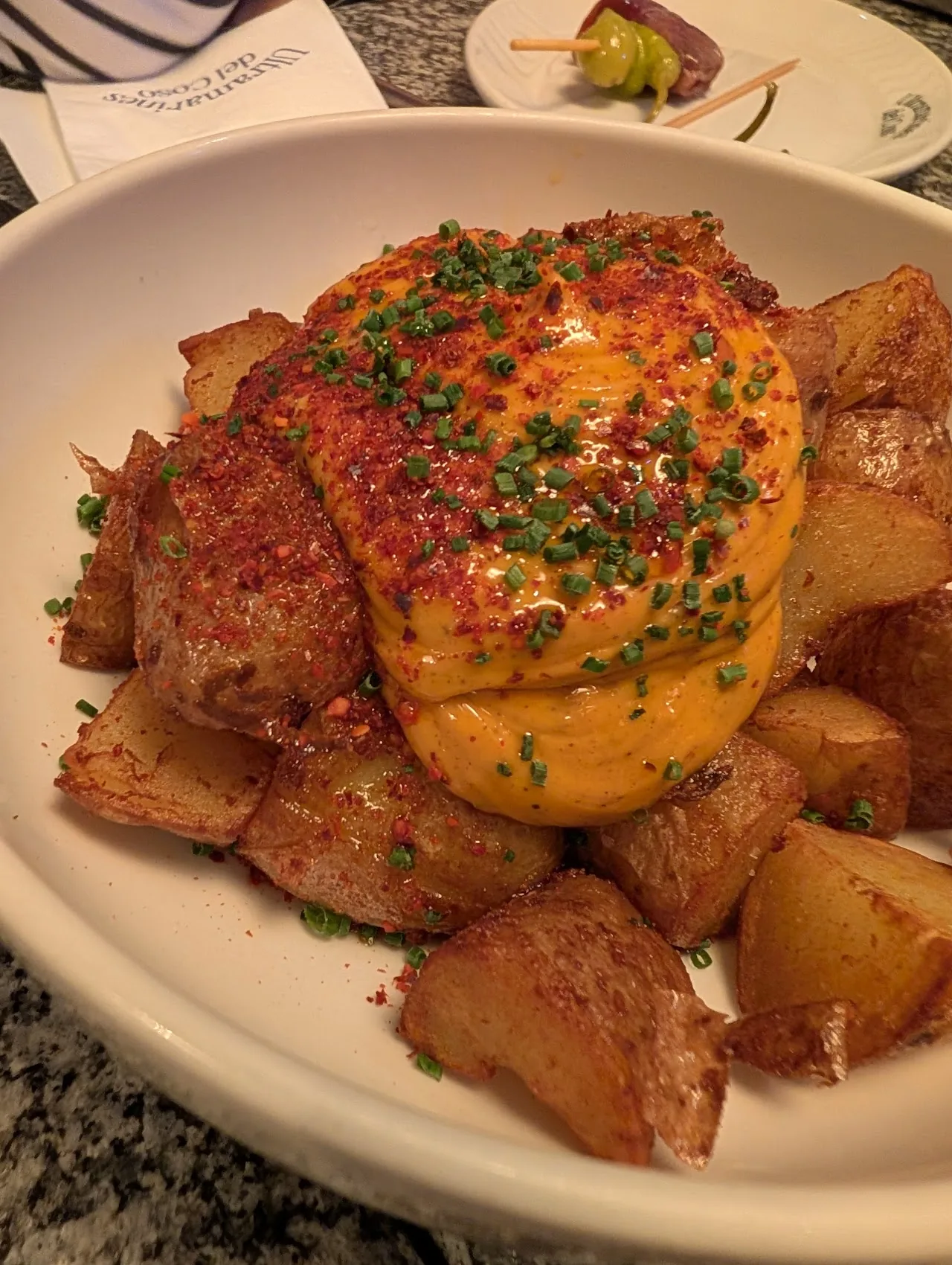 A whole roasted chicken with paprika, served with roasted potatoes