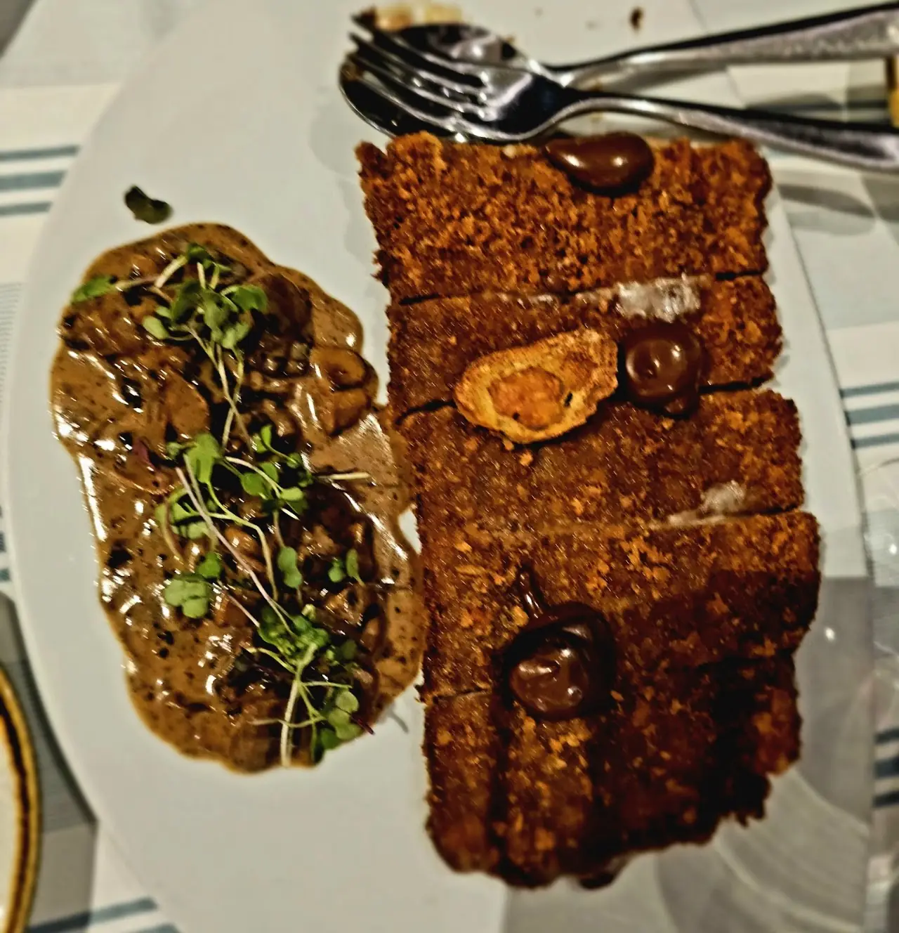 Toasted bread slices with a mushroom side dish, topped with dark sauce dots and micro greens.