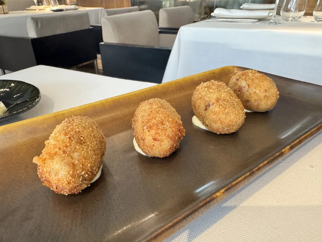 Breaded croquettes arranged on a dark platter
