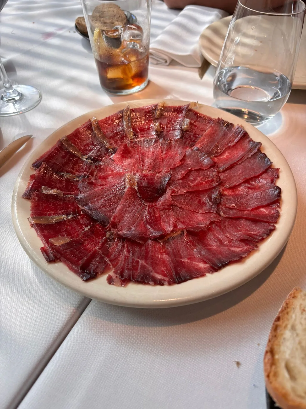 Thinly sliced cured beef arranged in a circle on a plate