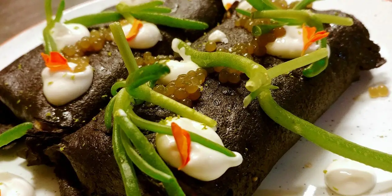 A savory dish with dollops of sauce, green beans, and citrus garnish.
