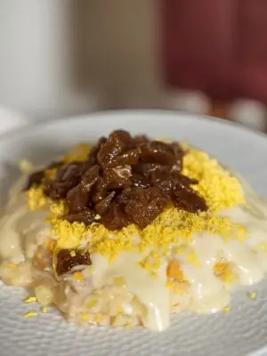 Plated ensaladilla rusa topped with grated egg and tuna belly