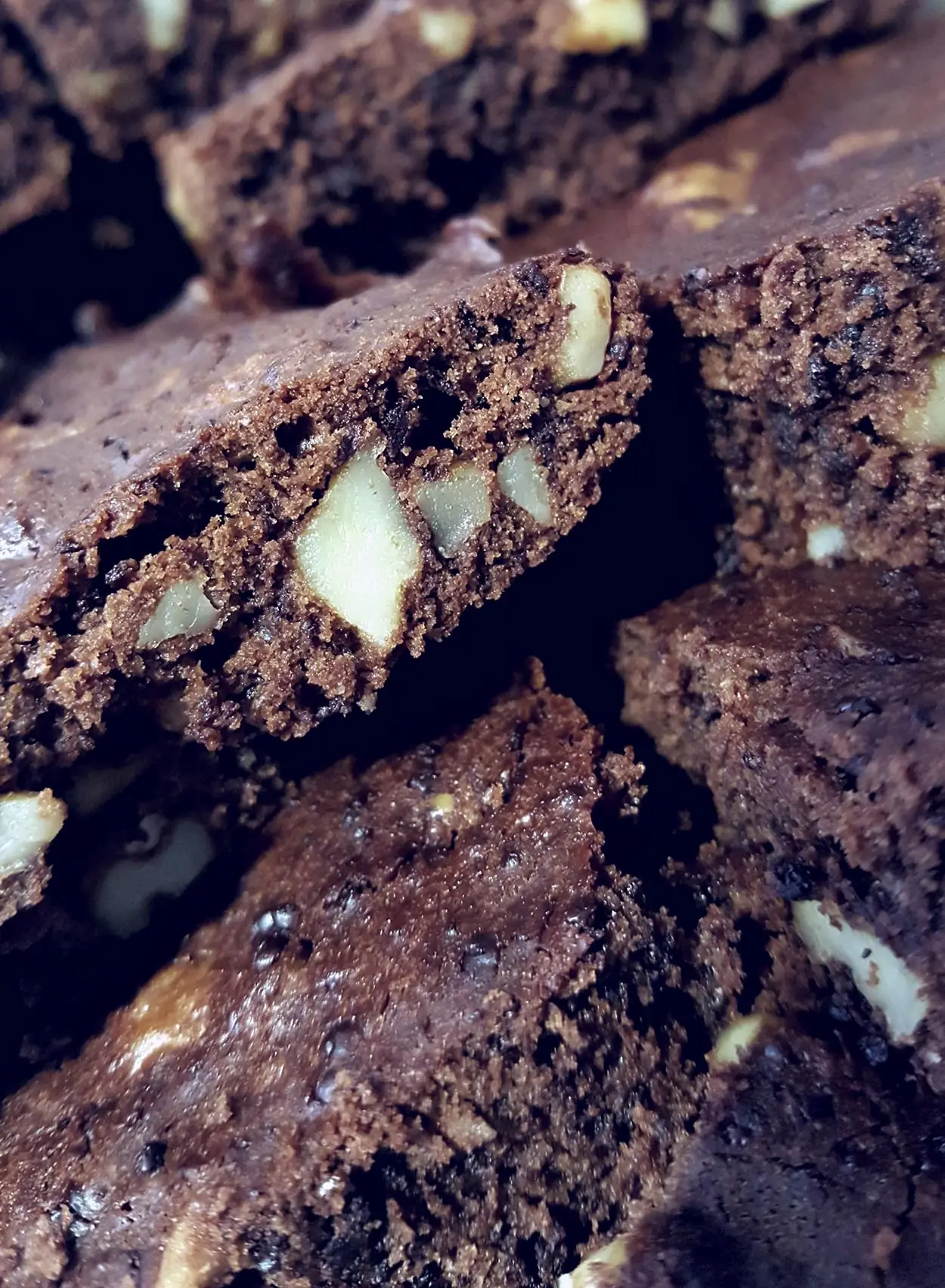 Close-up of stacked chocolate brownie squares studded with walnuts