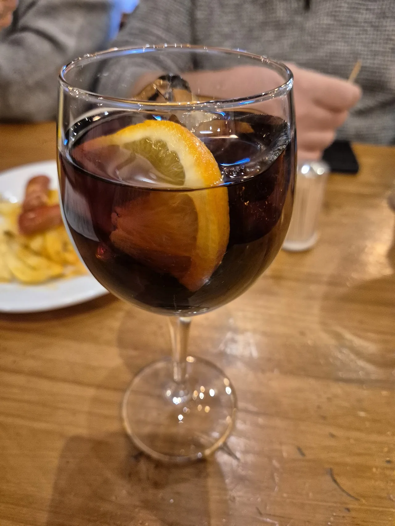 A glass of red sangria with an orange slice