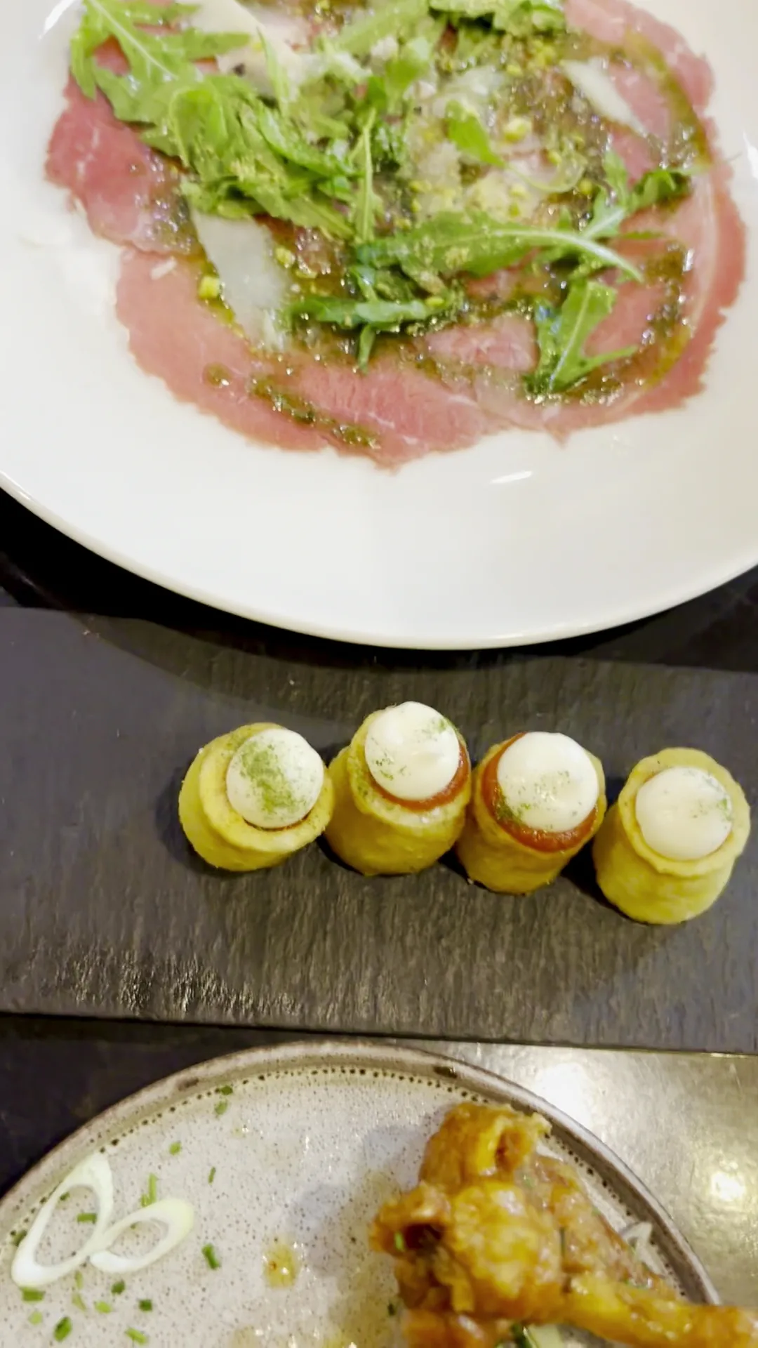 A plate of cured meat with herbs and croquettes