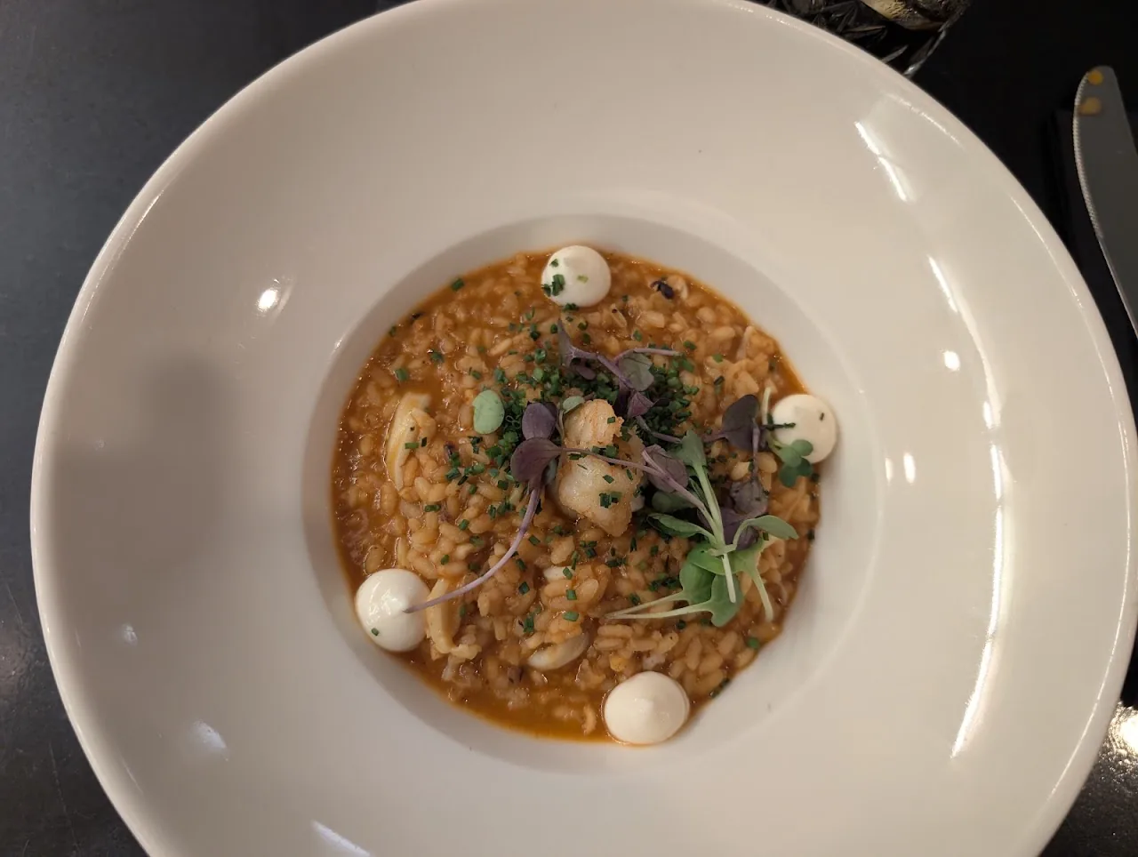 A plate of risotto with mussels and herbs