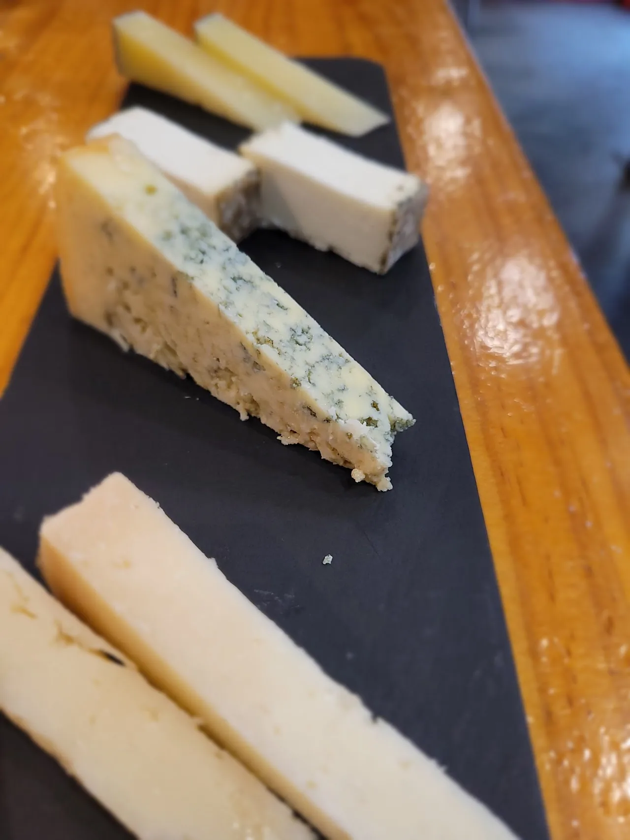 Wedges of blue cheese and white cheese on a slate board