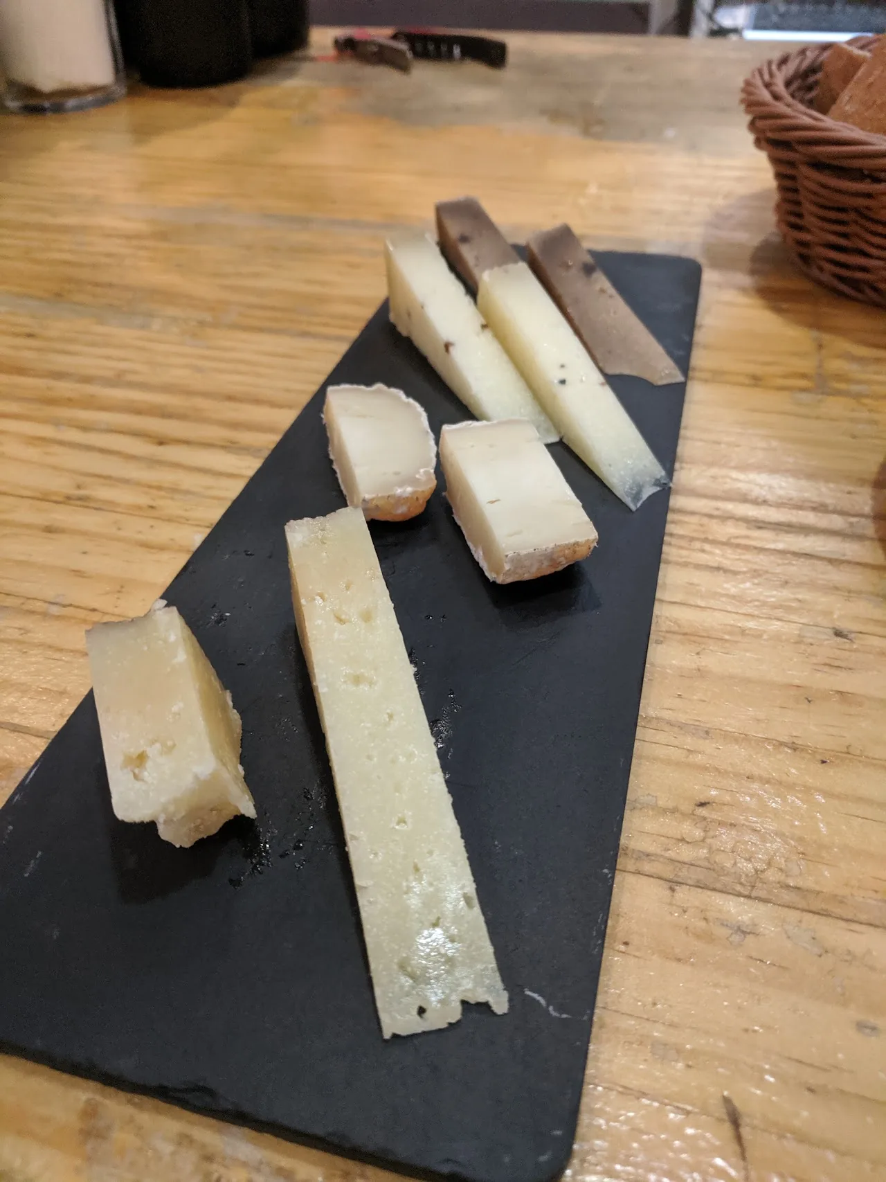 Sliced wedges of hard cheese arranged on a wooden board