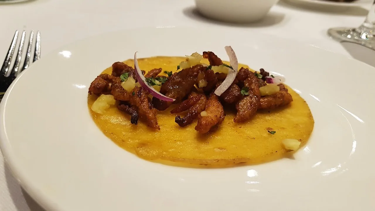 Grilled shrimp on a citrus puree, garnished with sliced onion