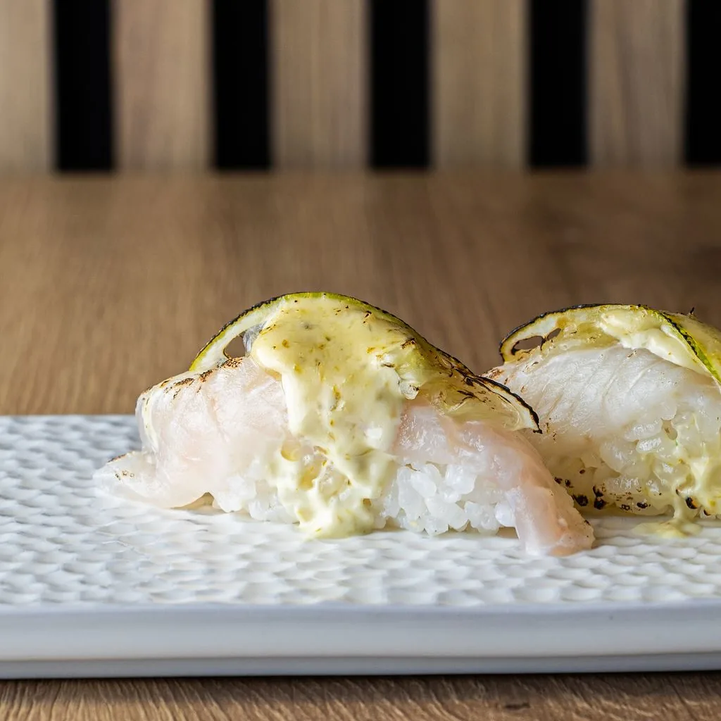 Two pieces of nigiri sushi with a citrus glaze