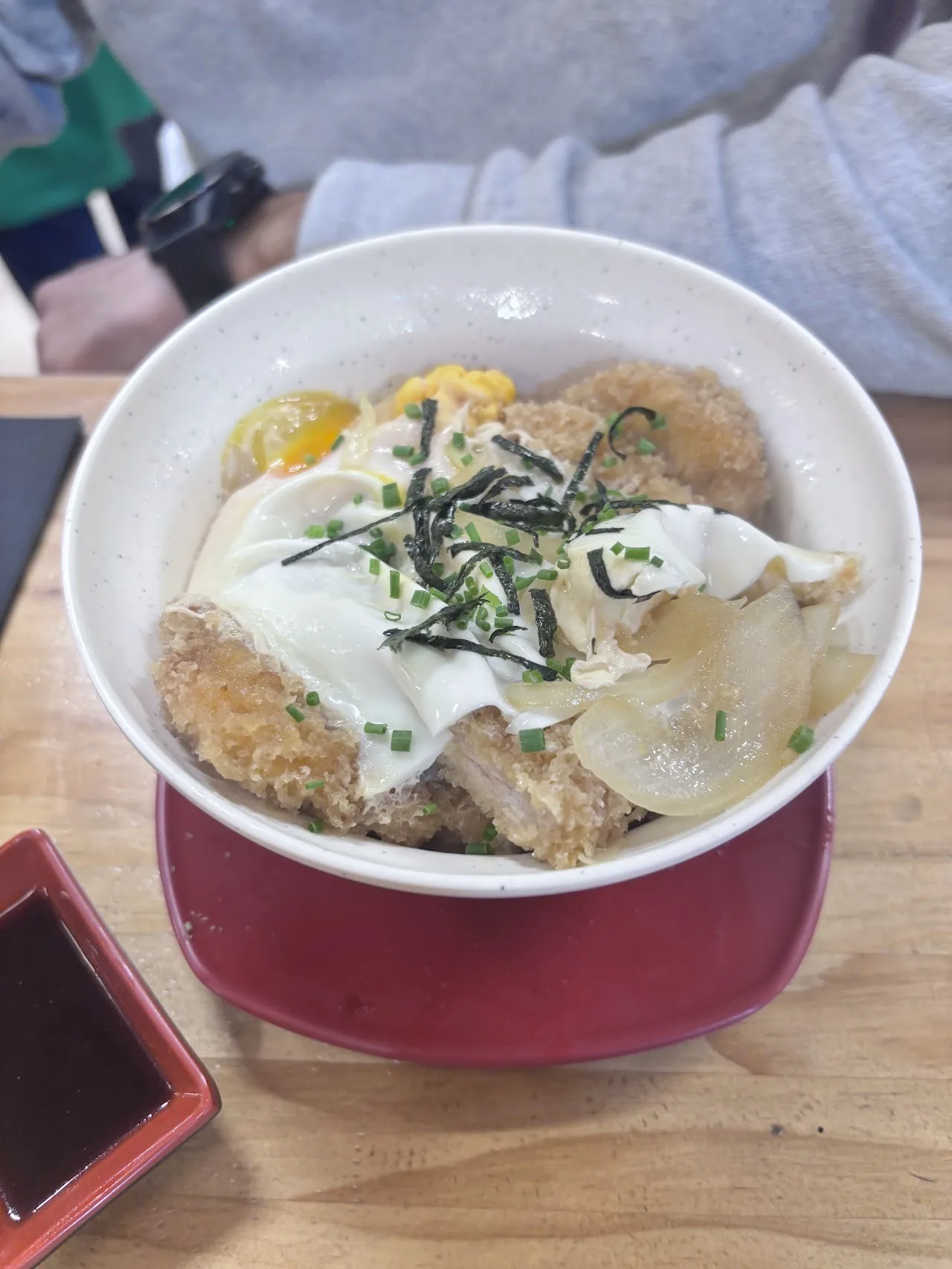 A bowl of rice topped with a fried cutlet, egg and shredded nori