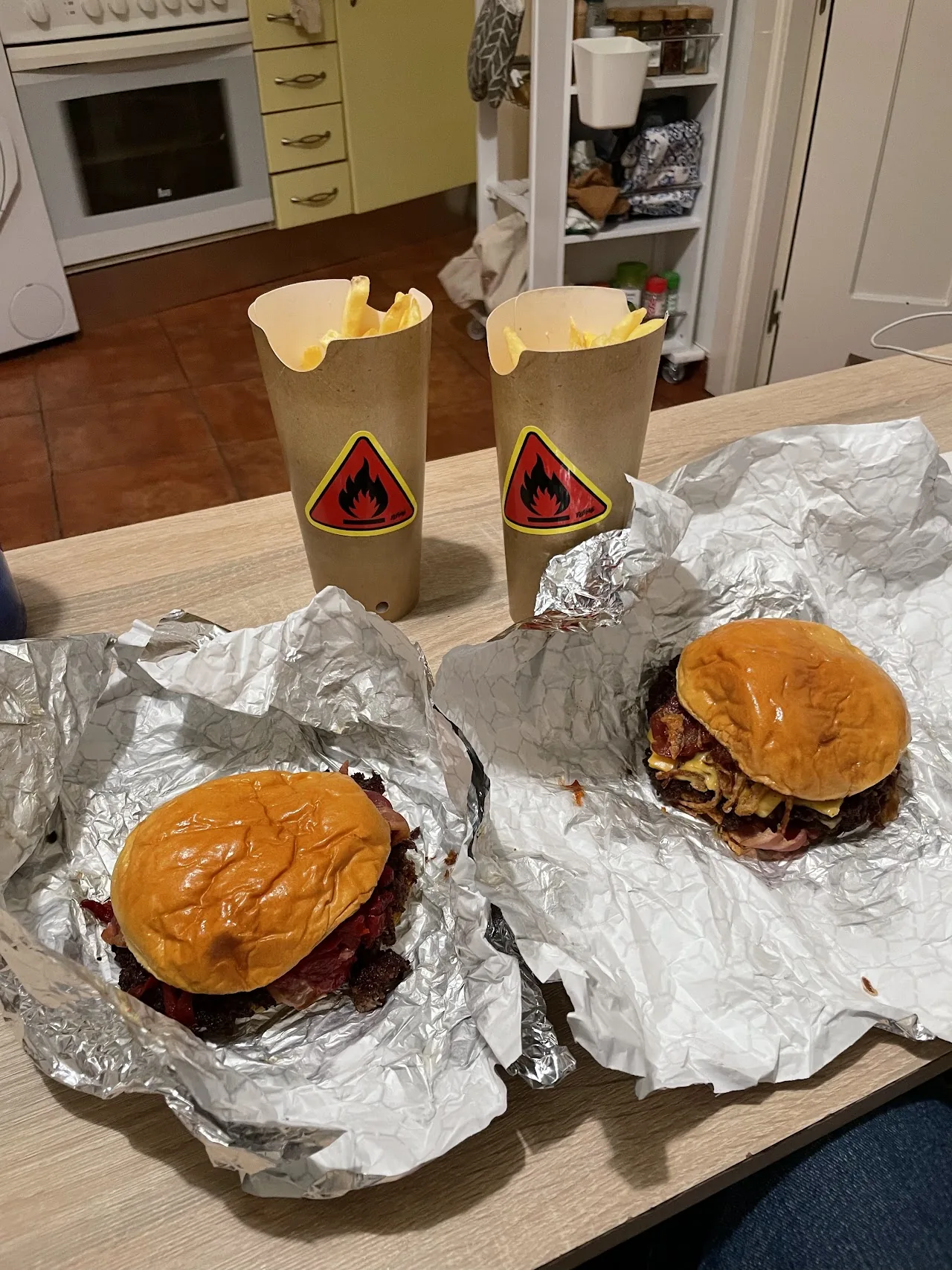 Two burgers wrapped in wax paper on a tray