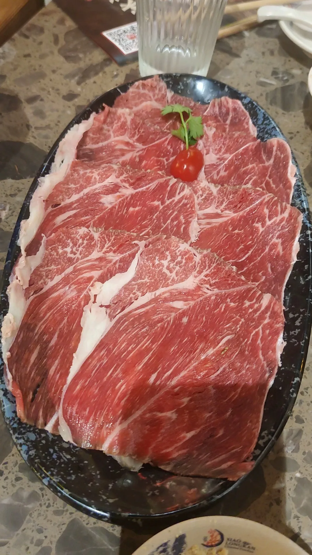 Thin slices of raw beef on a blue and white plate