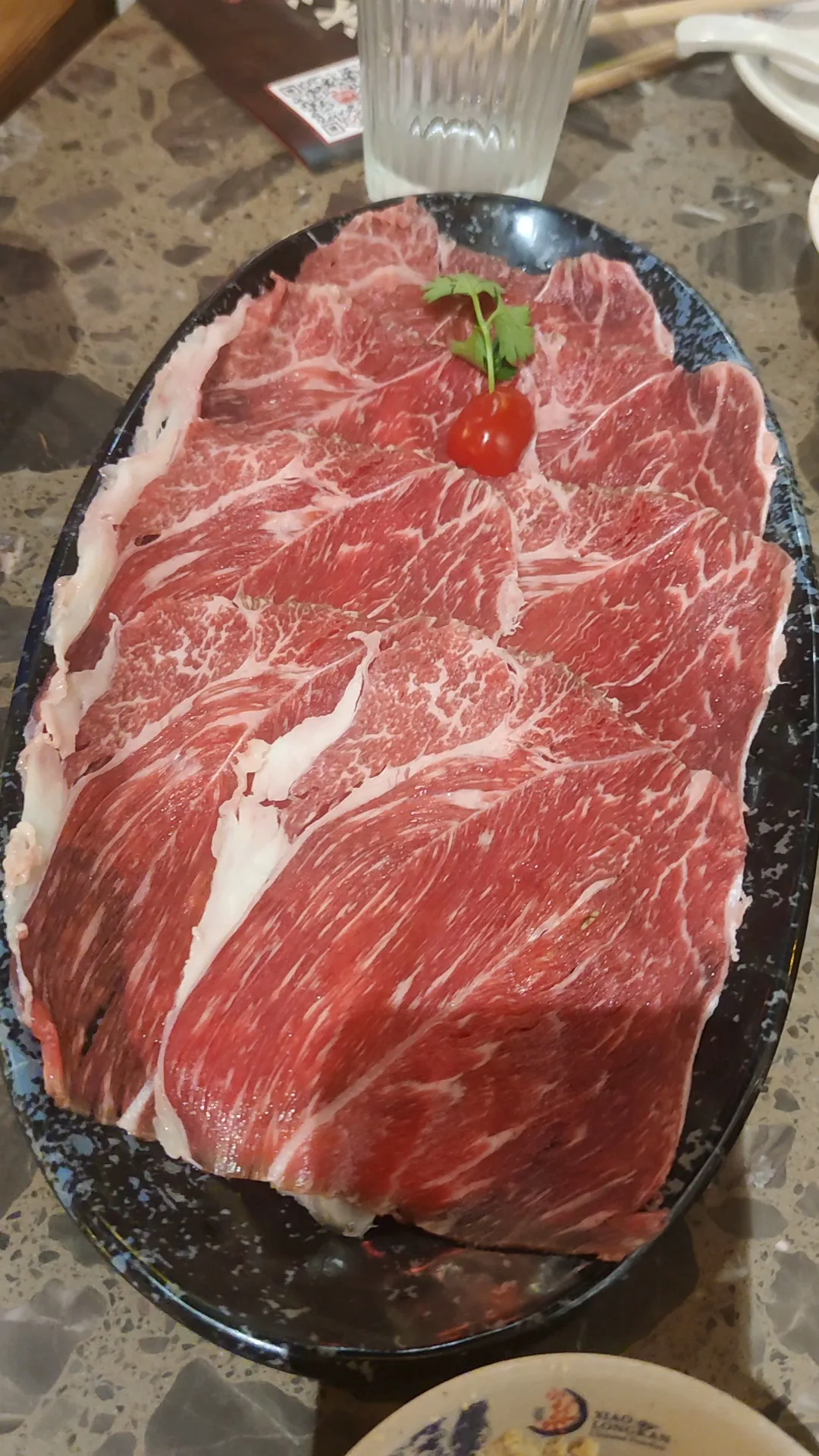 A plate of thinly sliced marbled raw beef