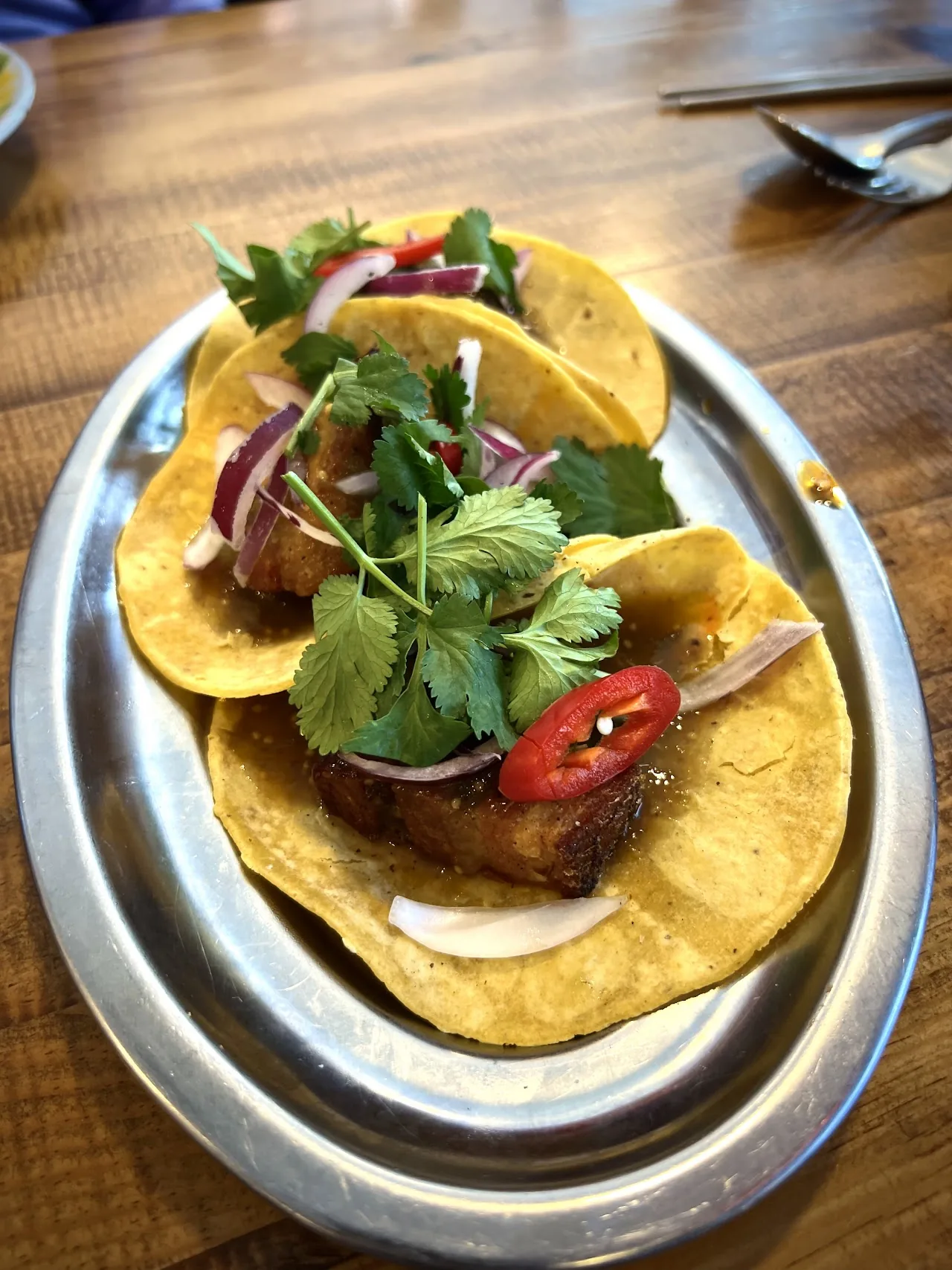 Corn tortilla tacos topped with meat, onion, and cilantro