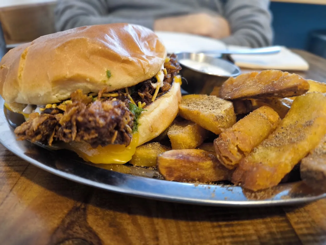 A sandwich on a roll with crispy spring rolls on the side