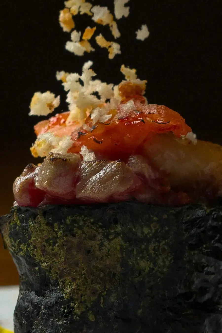 Nori cup filled with seafood and diced tuna, crispy garnish falling on top