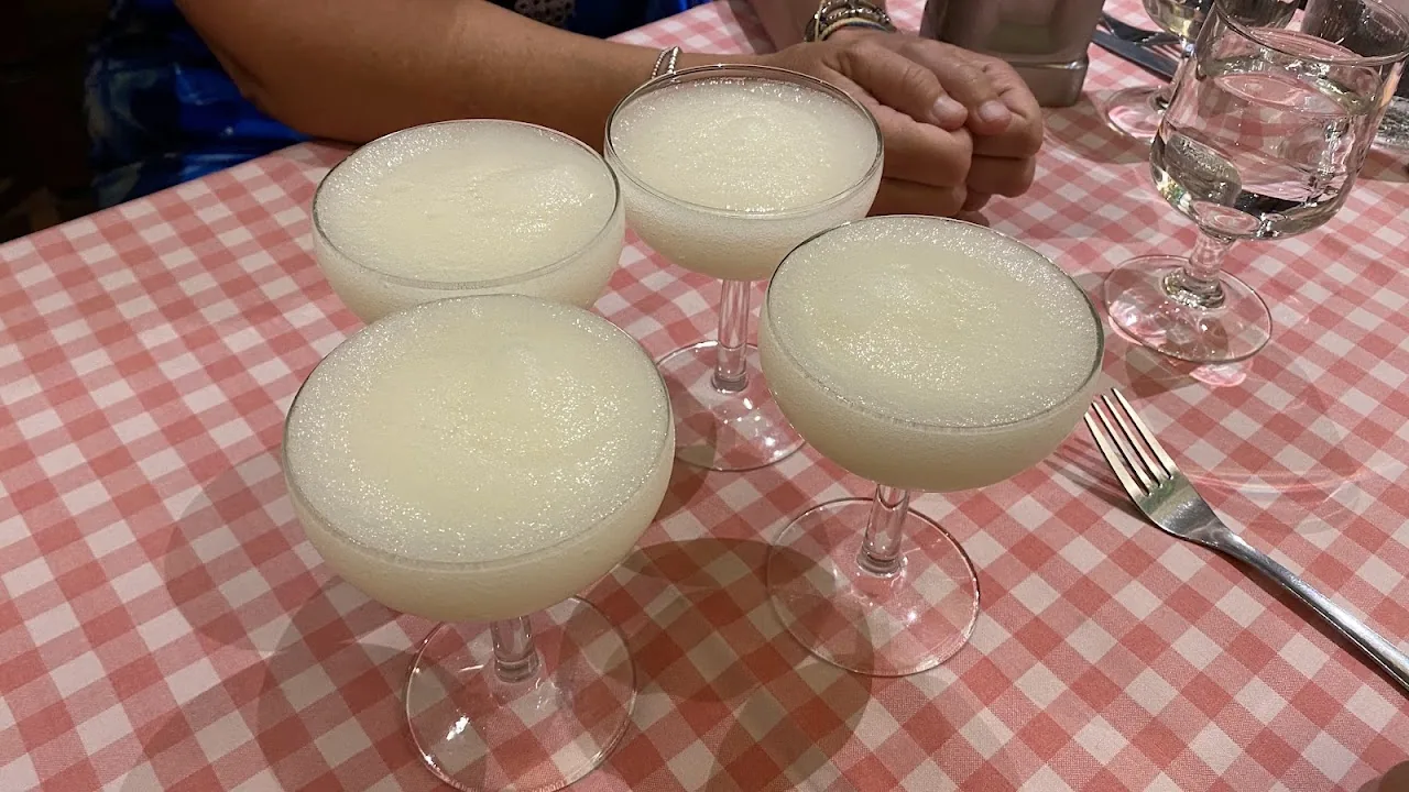 Four glasses of a creamy yellow blended drink