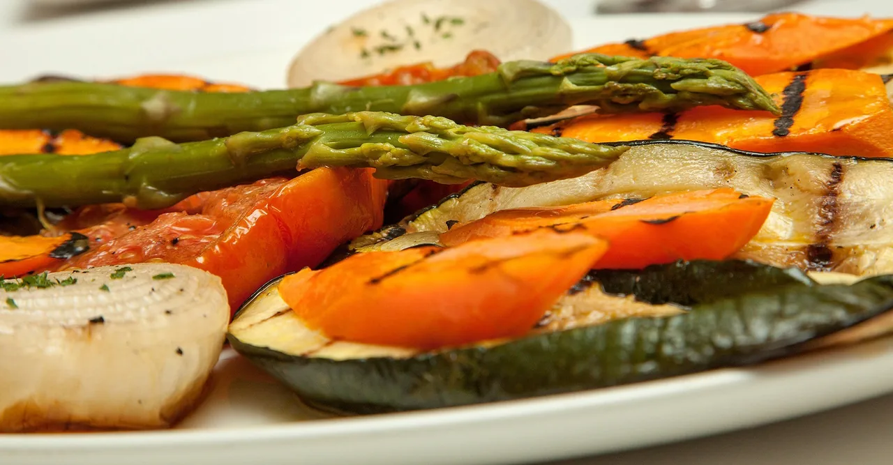 Grilled asparagus, peppers and other vegetables on a white plate